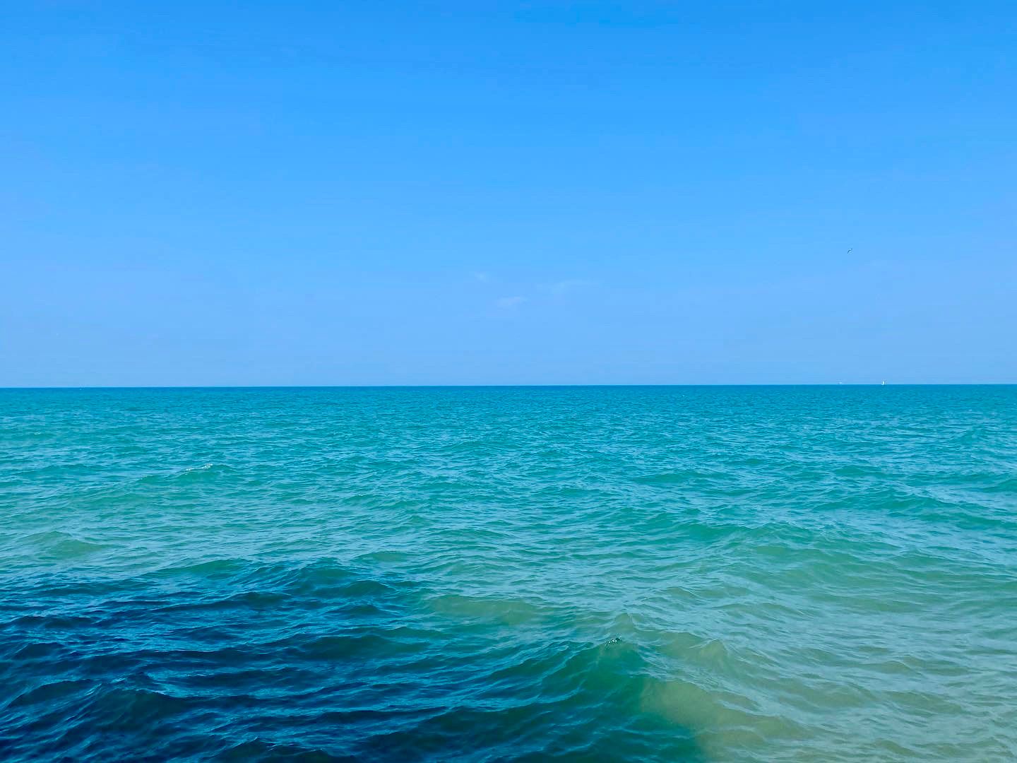 Lake horizon with clear blue sky above and calm turquoise water below